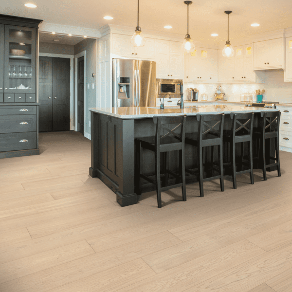 A kitchen with a large island and black chairs.