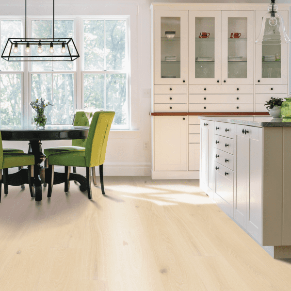 A kitchen with white cabinets and green chairs.