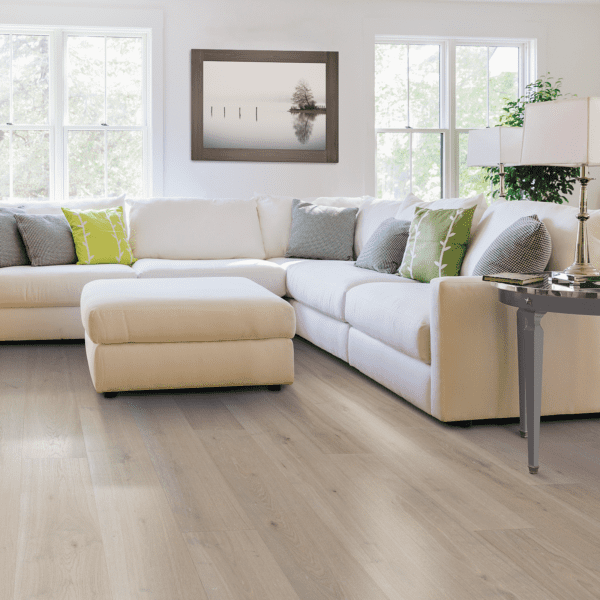 A living room with white furniture and large windows.
