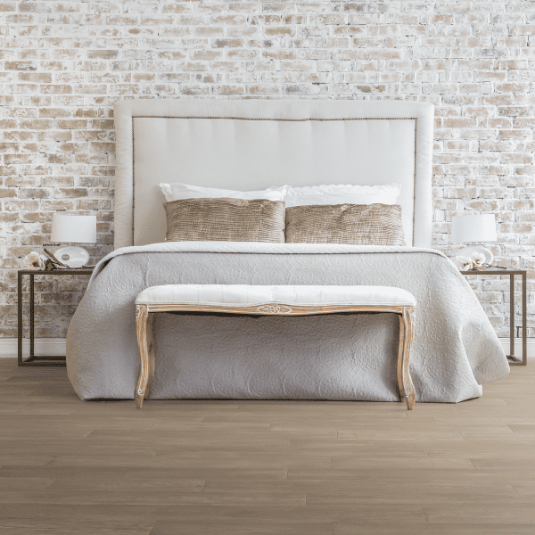 A bed with two tables and a bench in front of it