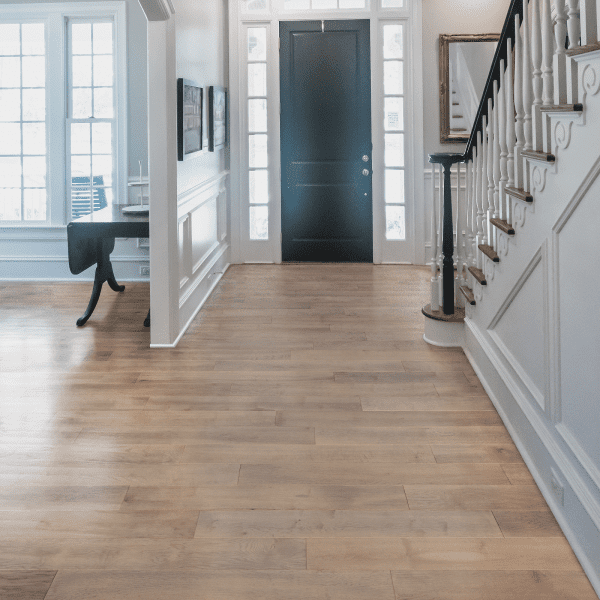 A hallway with stairs and a black door.