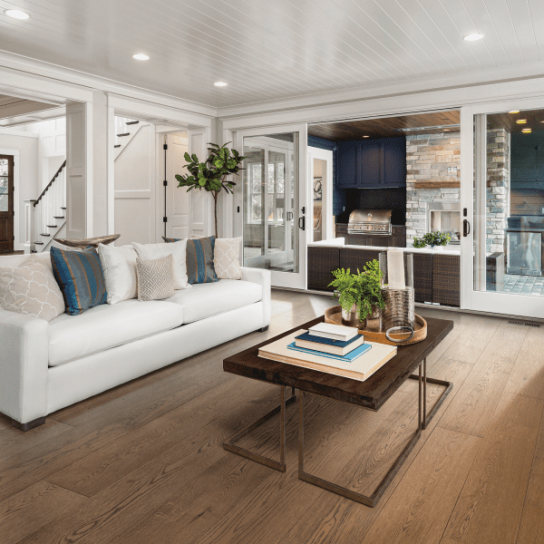 A living room with white furniture and wood floors.