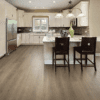 A kitchen with white cabinets and wooden floors.