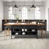 A kitchen with a large island and black cabinets.