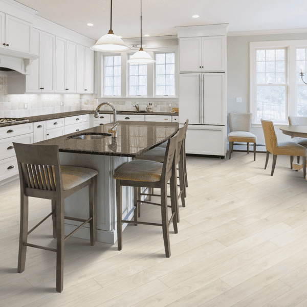 A kitchen with white cabinets and wooden floors.