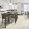 A kitchen with white cabinets and wooden floors.