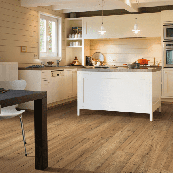 A kitchen with white cabinets and wooden floors.