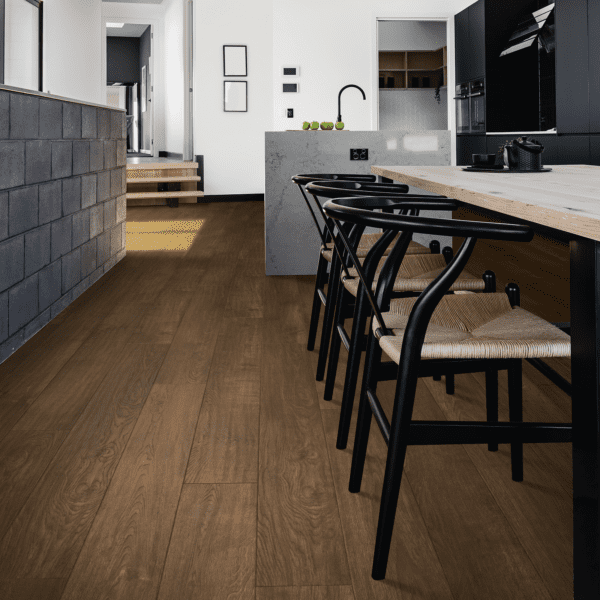 A kitchen with wooden floors and black chairs.