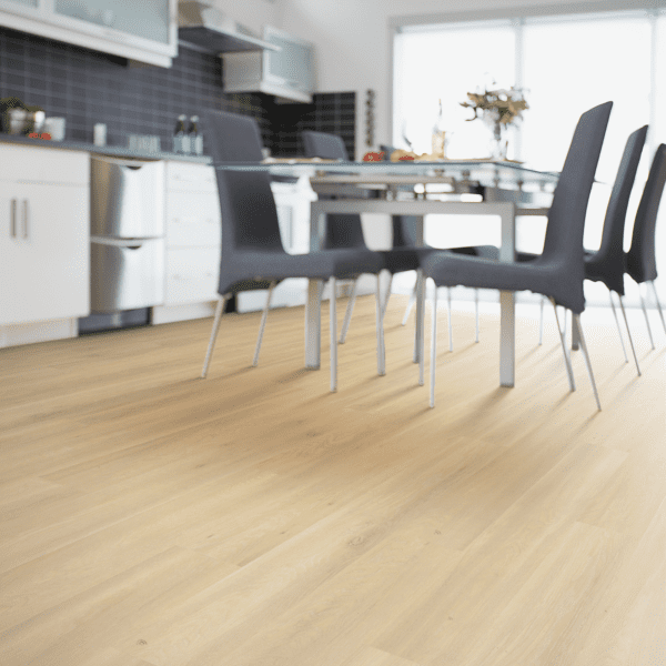 A dining room table and chairs in front of a kitchen.