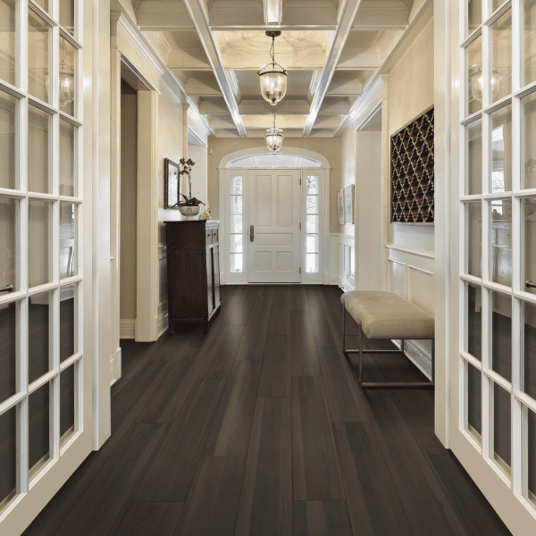A hallway with two doors and a chair.