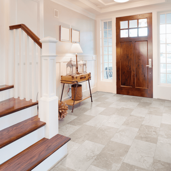 A foyer with stairs and a wooden door.
