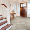 A foyer with stairs and a door leading to the second floor.