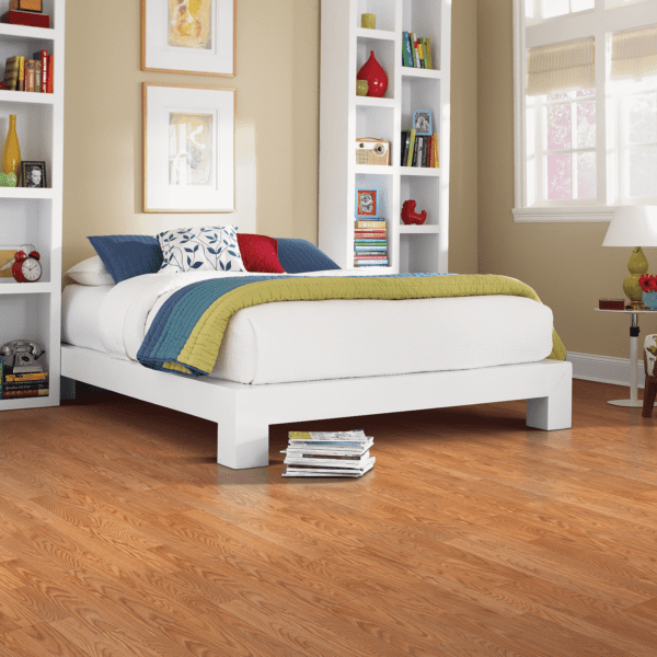A bedroom with hard wood floors and white furniture.