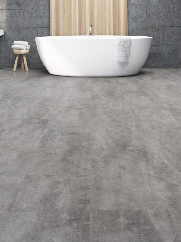 A bathroom with a tub and a towel on the floor.