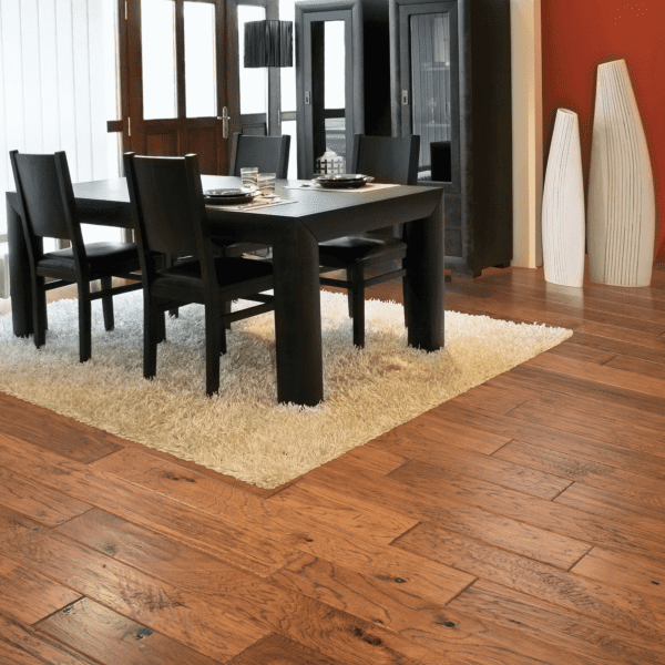 A dining room with wooden floors and black chairs.