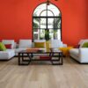 A living room with white furniture and red walls.