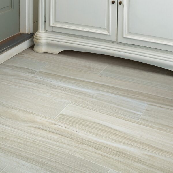 A white kitchen with wooden floors and cabinets.