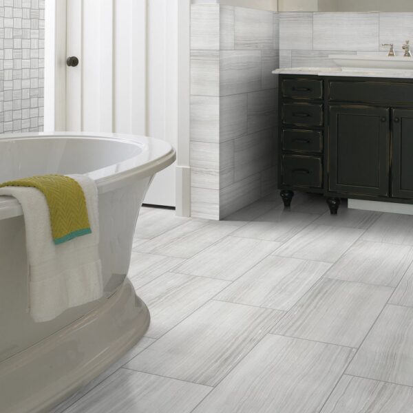 A bathroom with white tile and black vanity.