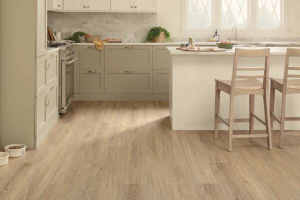 A kitchen with white cabinets and wood floors.