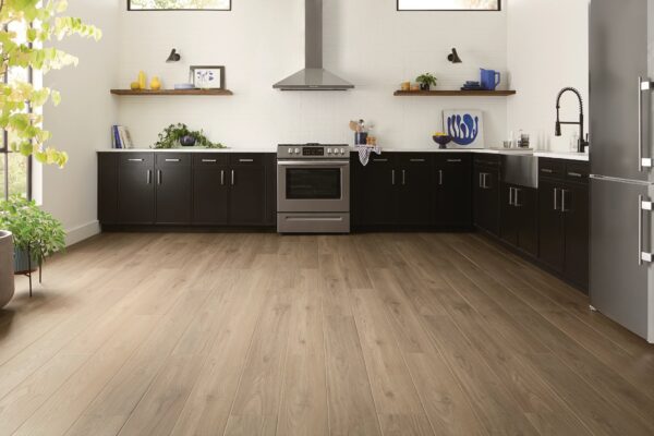 A kitchen with wooden floors and black cabinets.