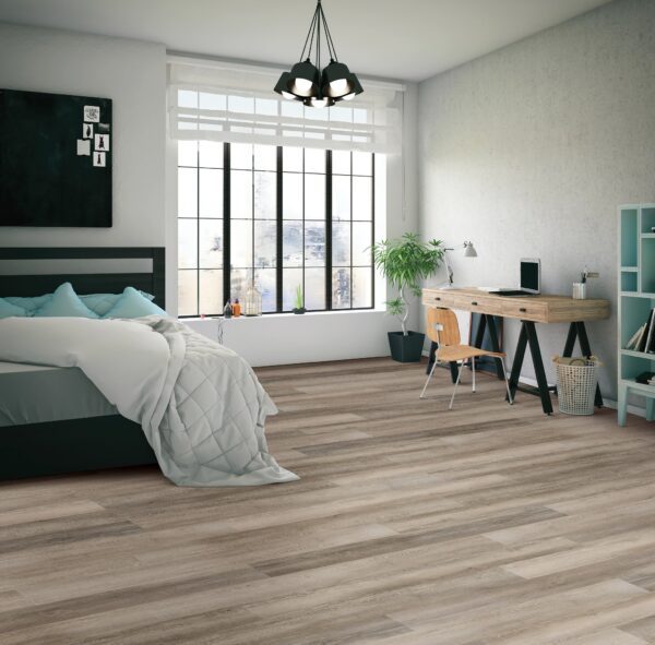 A bedroom with a bed, desk and window.