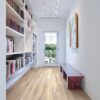 A hallway with bookcases and a bench in the middle.