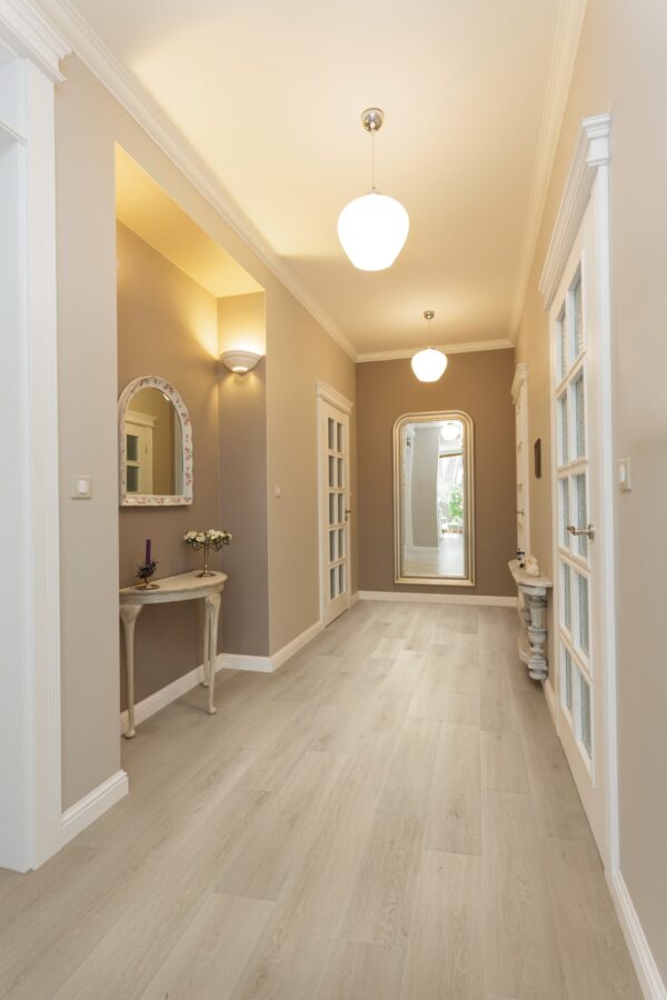 A hallway with a mirror and a table in it