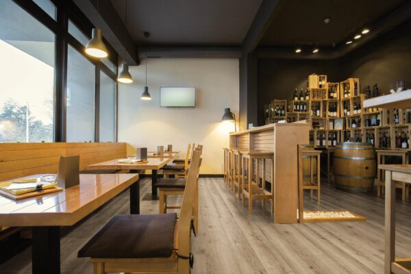 A restaurant with wooden tables and chairs, and a bar.