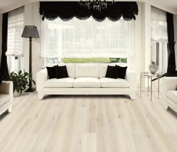 A living room with white furniture and black pillows.