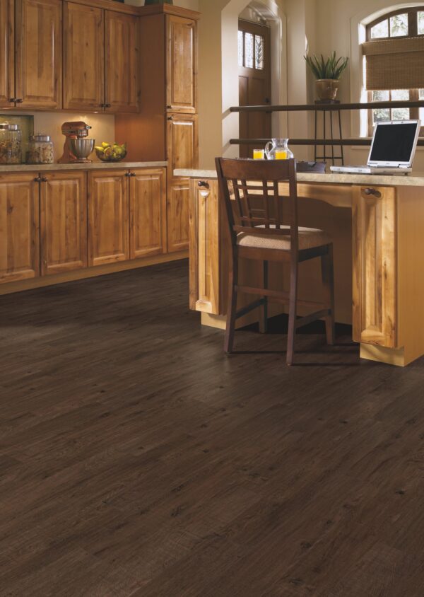 A kitchen with wooden cabinets and floors.