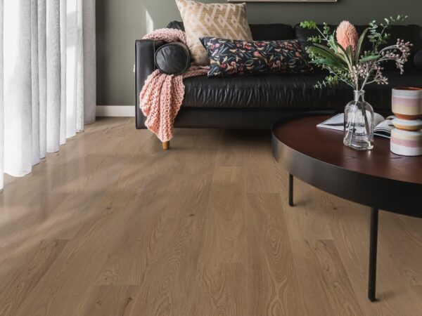 A living room with a black couch and wooden floors