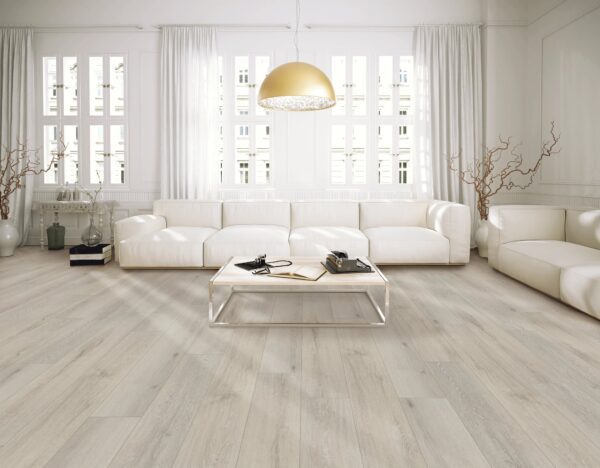 A living room with white furniture and large windows.