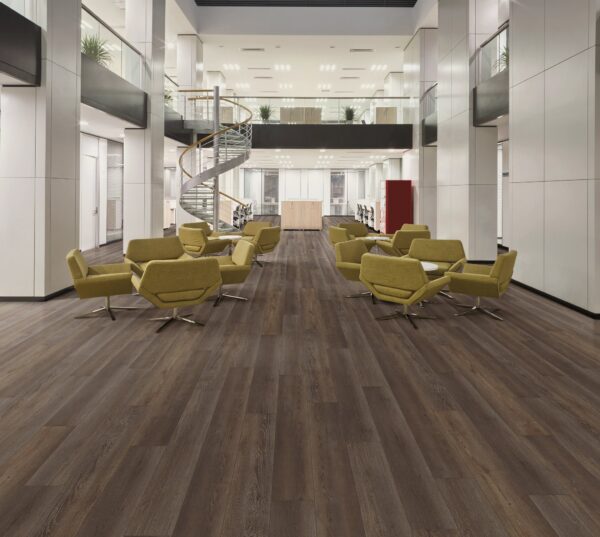 A large lobby with yellow chairs and wooden floors.