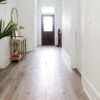 A hallway with wooden floors and white walls.