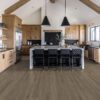 A kitchen with black chairs and a large island.