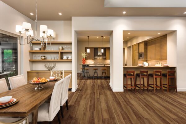 A dining room with a table and chairs, and a kitchen.