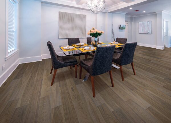 A dining room with a table and chairs, and a painting on the wall.