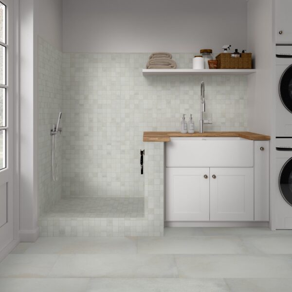 A white room with a sink and washer in it