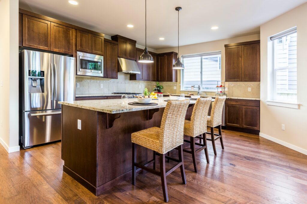A kitchen with wooden floors and brown cabinets.